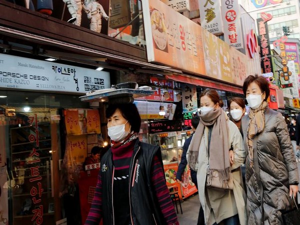 Women wearing masks as a preventive measure against the coronavirus walk at a traditional market in Seoul