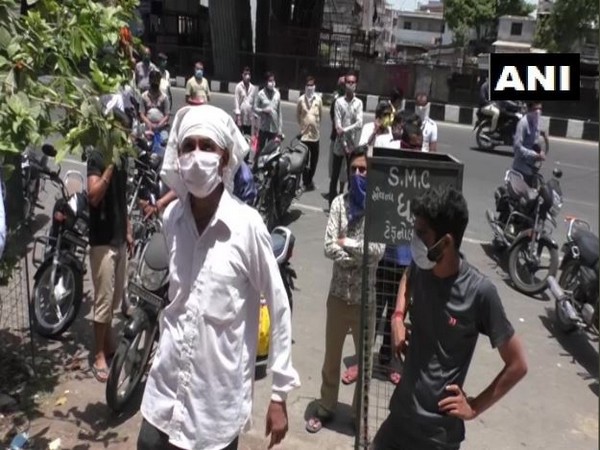 People queue up to buy tobacco in Surat. 