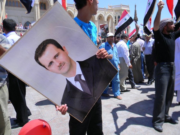 A portrait of President Bashar al-Assad in hands of a protestor