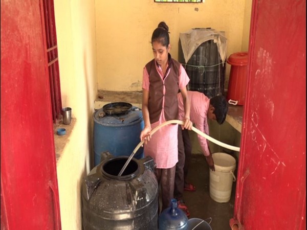 A school girl filling a tank with the rain harvested water at a government school in Agra [Photo/ANI]