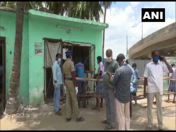 People stand in long queues outside a government-run TASMAC liquor shop.