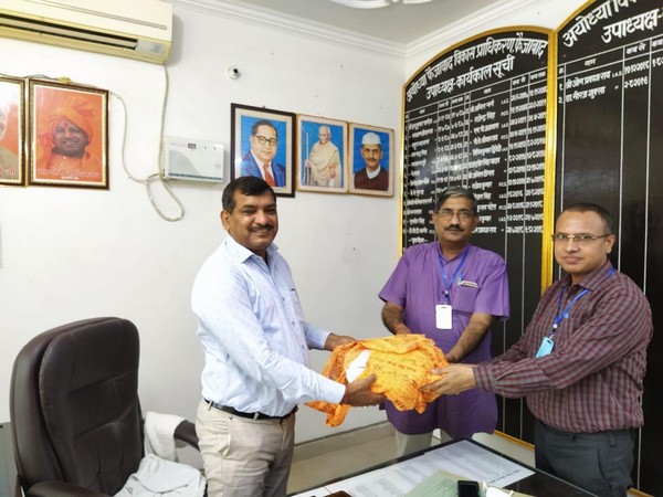 Dr Anil Mishra, member of Ram temple Trust handing over layout of Ram temple to ADA vice chairman Neeraj Shukla ( white shirt) on Saturday. (Picture source: Twitter/Shri Ram Janmbhoomi Teerth Kshetra)