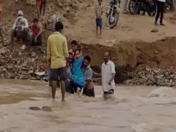 Woman being carried through an overflowing lake by family members to a hospital in Gundala on Friday. Photo/ANI