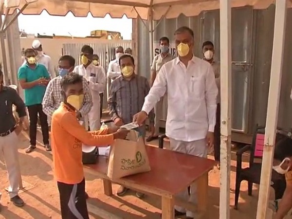 Telangana finance minister T Harish Rao giving ration to one of the migrant workers. Photo/ANI