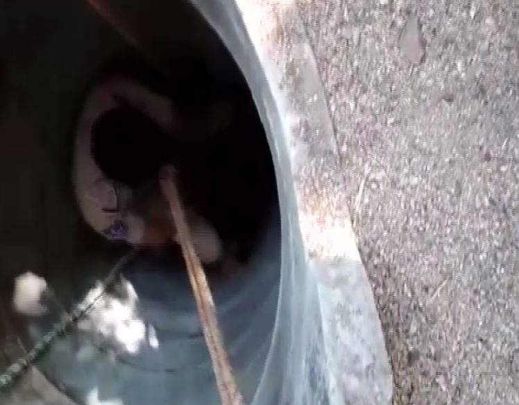 Jammikunta Circle Inspector Sujan Reddy climbing down the well to rescue two persons trapped in a well in Telangana on Tuesday. (Photo/ANI)