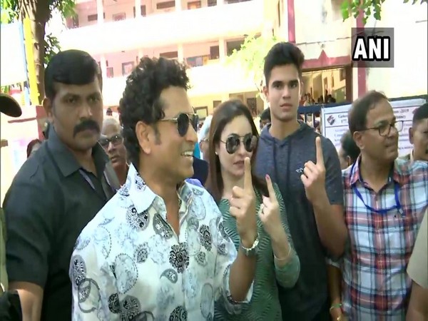 Sachin Tendulkar with wife Anjali and son Arjun, posing outside polling booth.