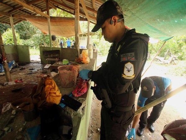 A Thai military personnel examine the site where villagers were killed in Yala province on late Tuesday