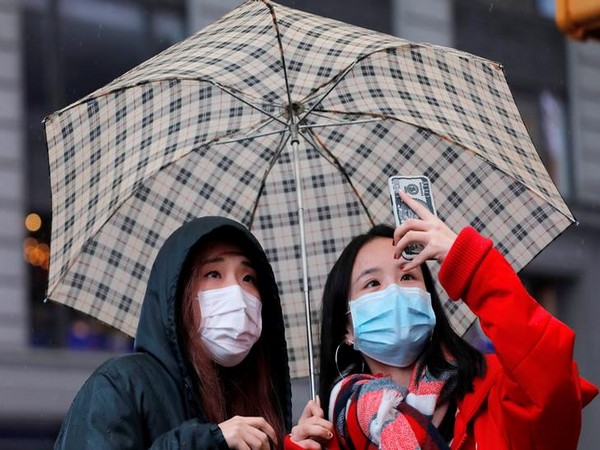 People wear face masks on Times Square after further cases of coronavirus were confirmed in New York City
