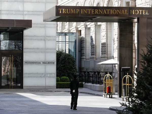 A staff member wears gloves while walking past an entranceway at Trump International Hotel, as Mayor Muriel Bowser declared a State of Emergency due to the coronavirus in Washington, US.