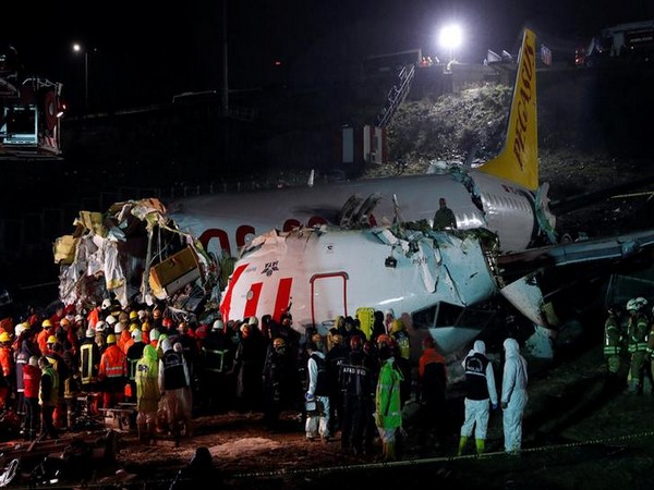    First responders gather around the Pegasus Airlines Boeing 737-86J plane wreckage after it overran the runway during landing and crashed, at Istanbul's Sabiha Gokcen airport.
