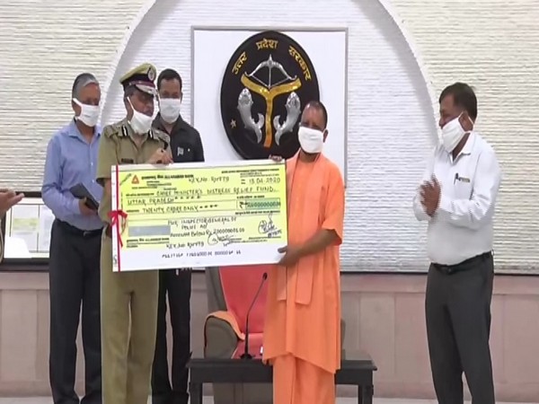 UP Police DGP hands over a cheque of Rs 20 crore to CM Yogi Adityanath in Lucknow on Wednesday. Photo/ANI