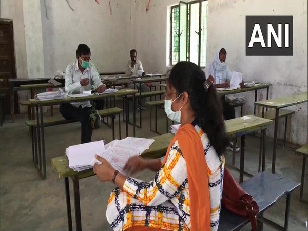 Teachers evaluate exam sheets while maintaining social distance in Prayagraj on Sunday. [Photo/ANI]  