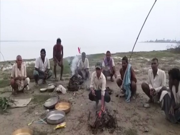 Locals of villages submerged into River Ganga offer special prayers at riverbank. Photo/ANI