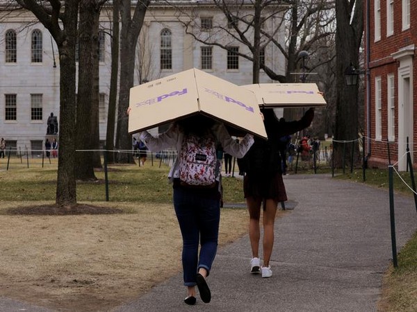 Students carry boxes to their dorms at Harvard after the university asked its students to take virtual classes after spring break.