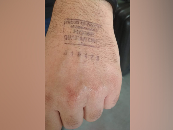 'Home quarantine' stamp on the hand of four passengers. Photo/ANI