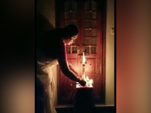 A visual of a doctor lighting lamp at her home before performing the dance in Kerala. 