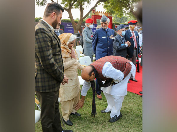 Defence Minister Rajnath Singh touching feet of wife of 1971 war veteran