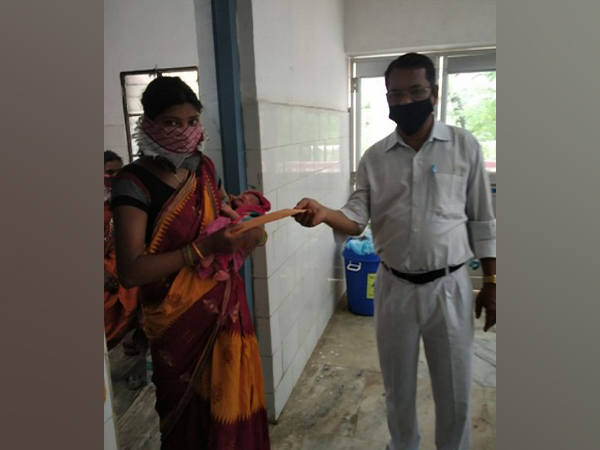 ECoR official giving gift coupon to mother of a baby born on board Shramik Special Train