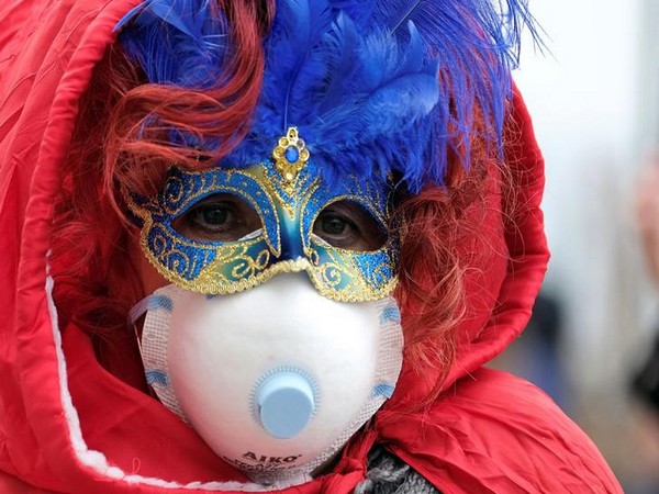 Masked Carnival reveler wearing a protective face mask at Venice Carnival, amid outbreak coronavirus, in Venice, Italy.