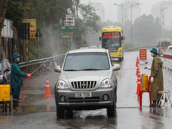 Members of anti-coronavirus team spray chemical in vehicles on a road in Thai Nguyen province in Vietnam.