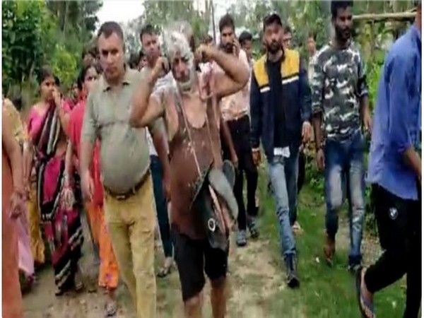 Man being paraded in village of Assam with a garland of shoes