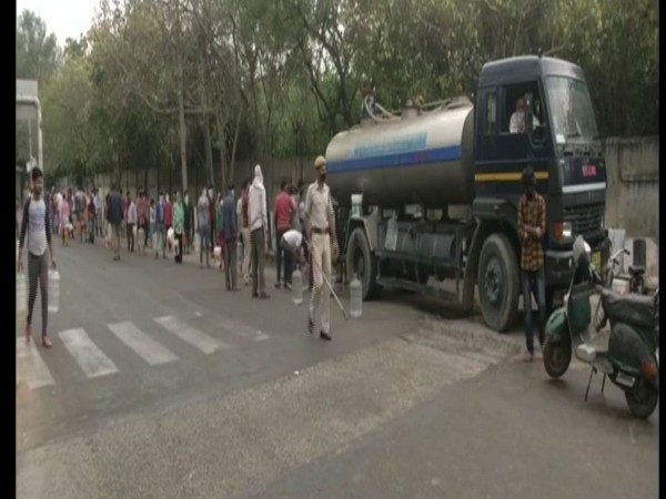 Locals stand in a queue to collect water in Chilla village. Photo/ANI