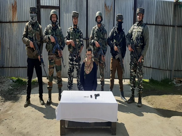 Security forces with the apprehended JeM terrorist on Saturday. 