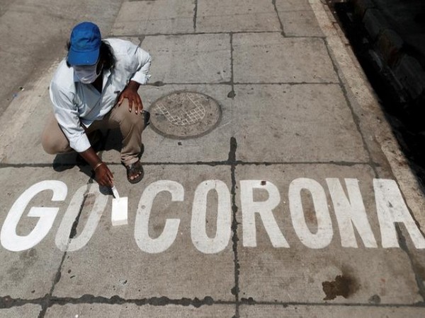 A man writes 'Go Corona' on a street amidst 21-day-long lockdown in India