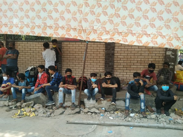 Migrant workers stand in long queues outside screening centre to seek information in New Delhi. 