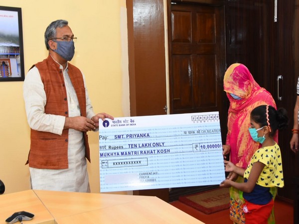 CM Trivendra Singh Rawat handing the cheque to the constable's widow. Photo/ANI