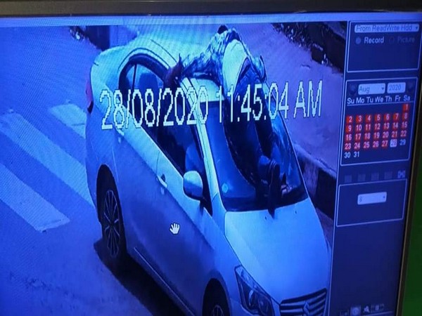 Sub Inspector broking the front mirror of the car in a screen grab of CCTV footage. 