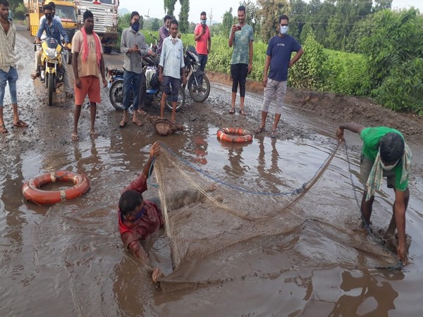 CPM workers were seen protesting with fishing net in road with potholes in Vizianagaram, Andhra Pradesh. (Photo/ANI)