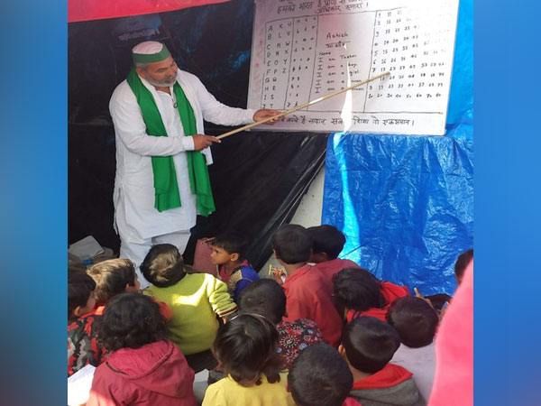 Rakesh Tikait teaching children at a makeshift school running on the farmers' agitation site at Ghazipur. (Photo/ANI)