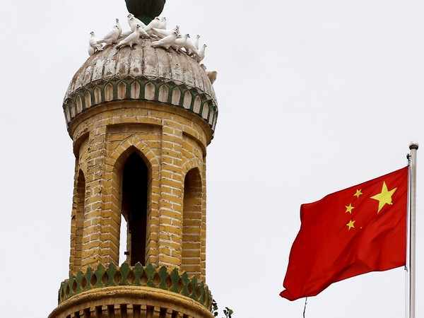 A Chinese national flag flutters near a minaret of the ancient Id Kah Mosque in the Old City in Kashgar in Xinjiang Uyghur Autonomous Region, China 