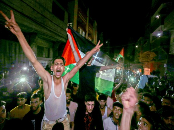 Palestinians celebrate in the streets following a ceasefire, in the southern Gaza Strip 