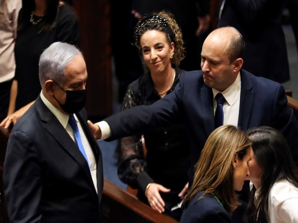 Head of Oposition Benjamin Netanyahu and Israel Prime Minister Naftali Bennett gesture following the vote on the new coalition at the Knesset