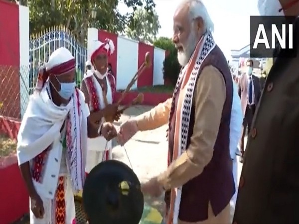 PM Modi trying his hand at playing a gong in Imphal on Tuesday. (Photo/ANI)