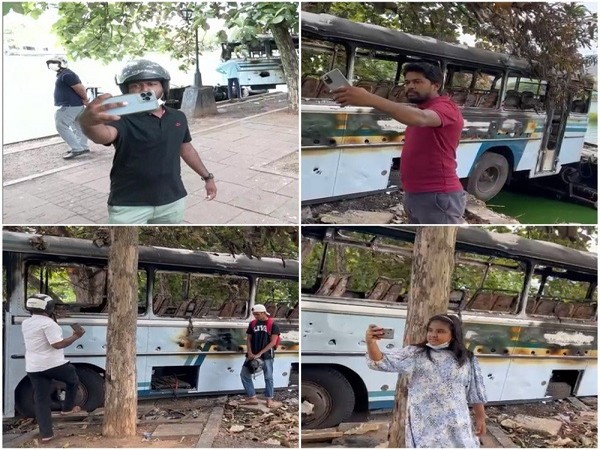 People gather up to take selfies near burnt, submerged buses in Sri Lanka's Colombo