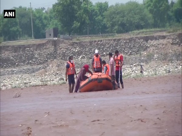 The woman getting onto the rescue boat as SDRF personnel watch