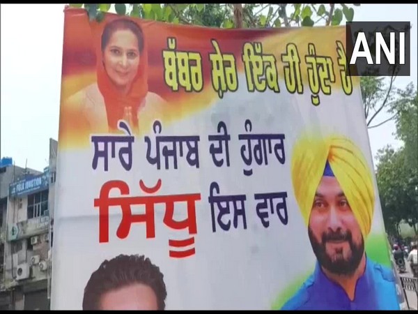 Supporter puts up poster of Congress MLA Navjot Singh Sidhu, his wife in Ludhiana. (Photo/ANI)