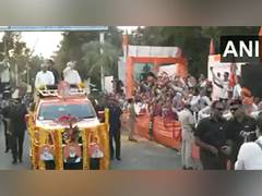 
      
      People shower flower petals on PM Modi, CM Bhupendra Patel
      
      