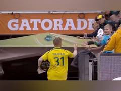 
      
      Warner gives his pair of gloves to a child after scoring century
      
      