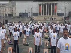 
      
      People perform yoga at Trafalgar Square in London
      
      