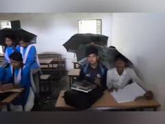 
      
      Students studying holding umbrellas as water drips from ceiling
      
      