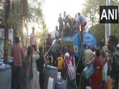 
      
      Many Delhi residents huddle around water tankers as city continue
      
      