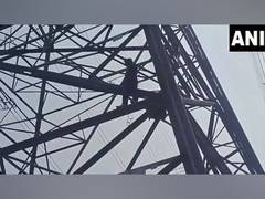 
      
      Unidentified man climbs high-voltage electric pole 
      
      
