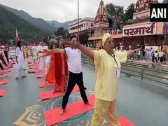 
      
      Swami Chidanand Saraswati and others perform Yoga at Ganga Ghat 
      
      