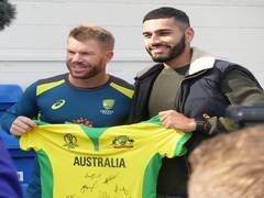 
      
      David Warner presents signed jersey to net bowler Jaykishan Phala
      
      