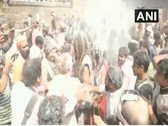 
      
      At Varanasi's Manikarnika Ghat, people celebrate Holi with...
      
      
