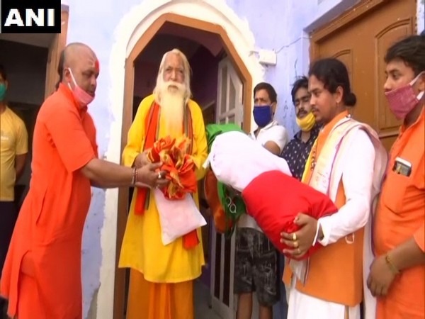 Pandit Kalki Ram handing over clothes to Acharya Satyendra Das in Ayodhya  on Sunday. (Photo/ANI)